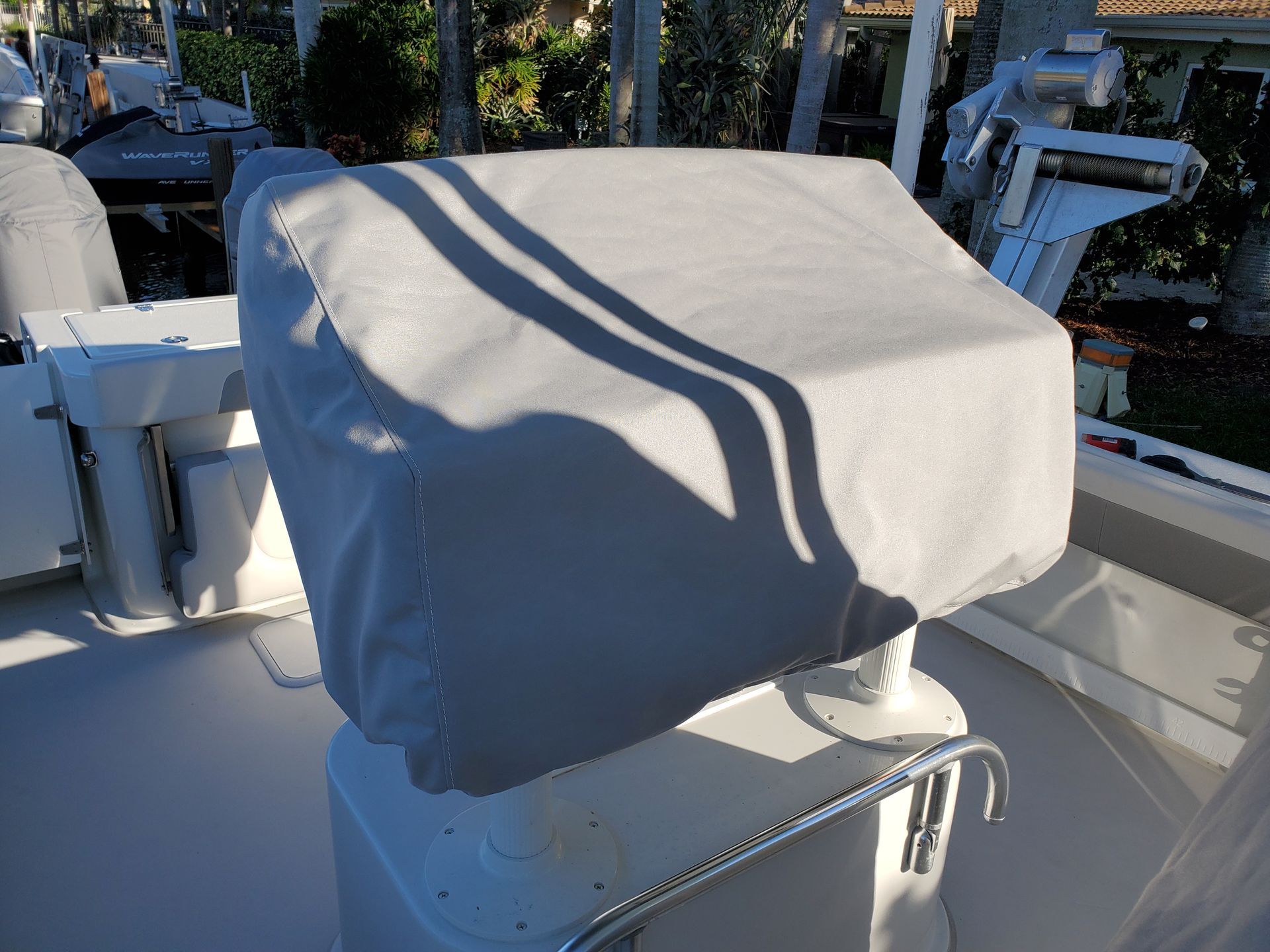 A white boat with a gray seat cover on it