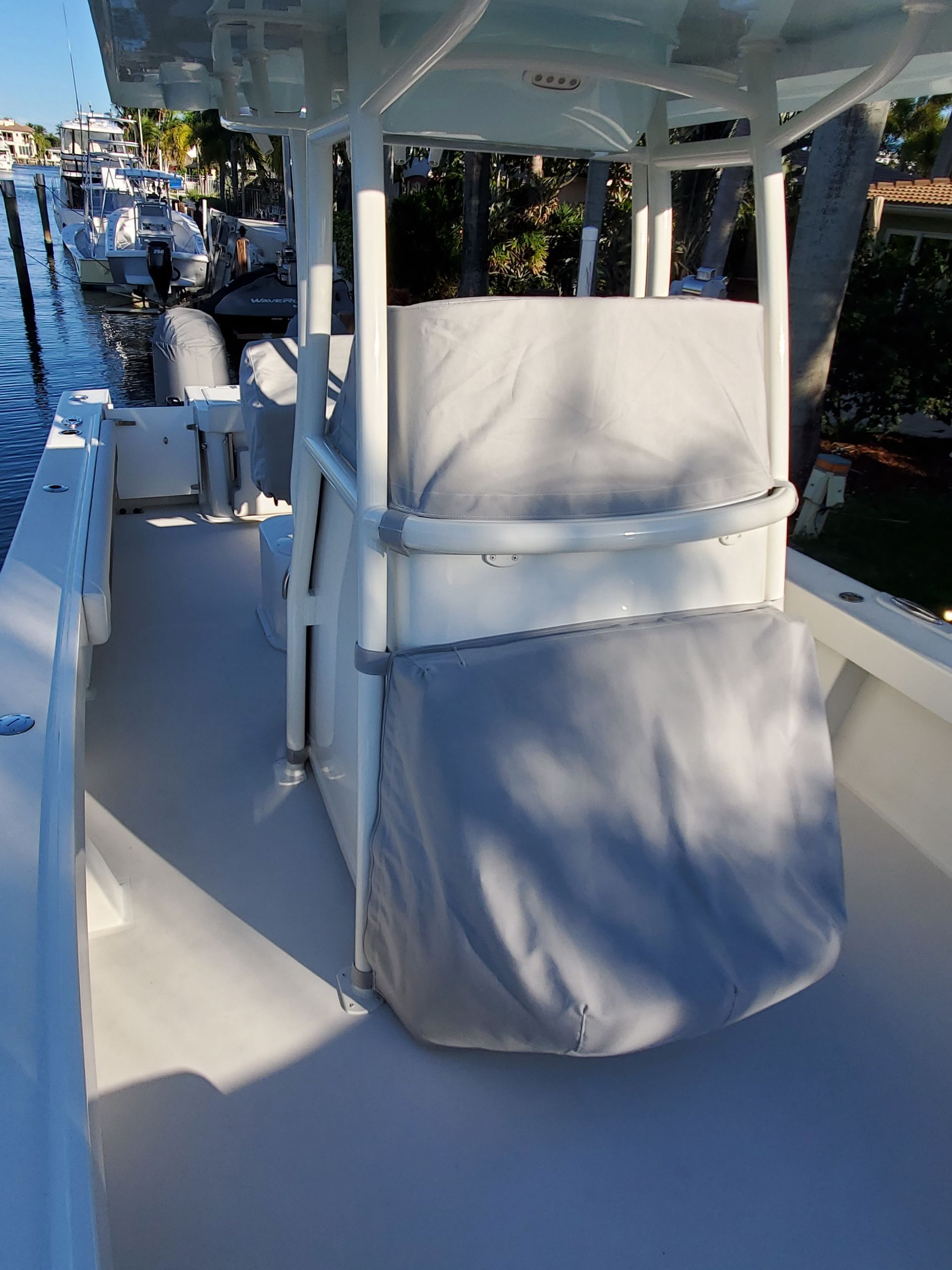 A white boat with a gray cover on the seat.