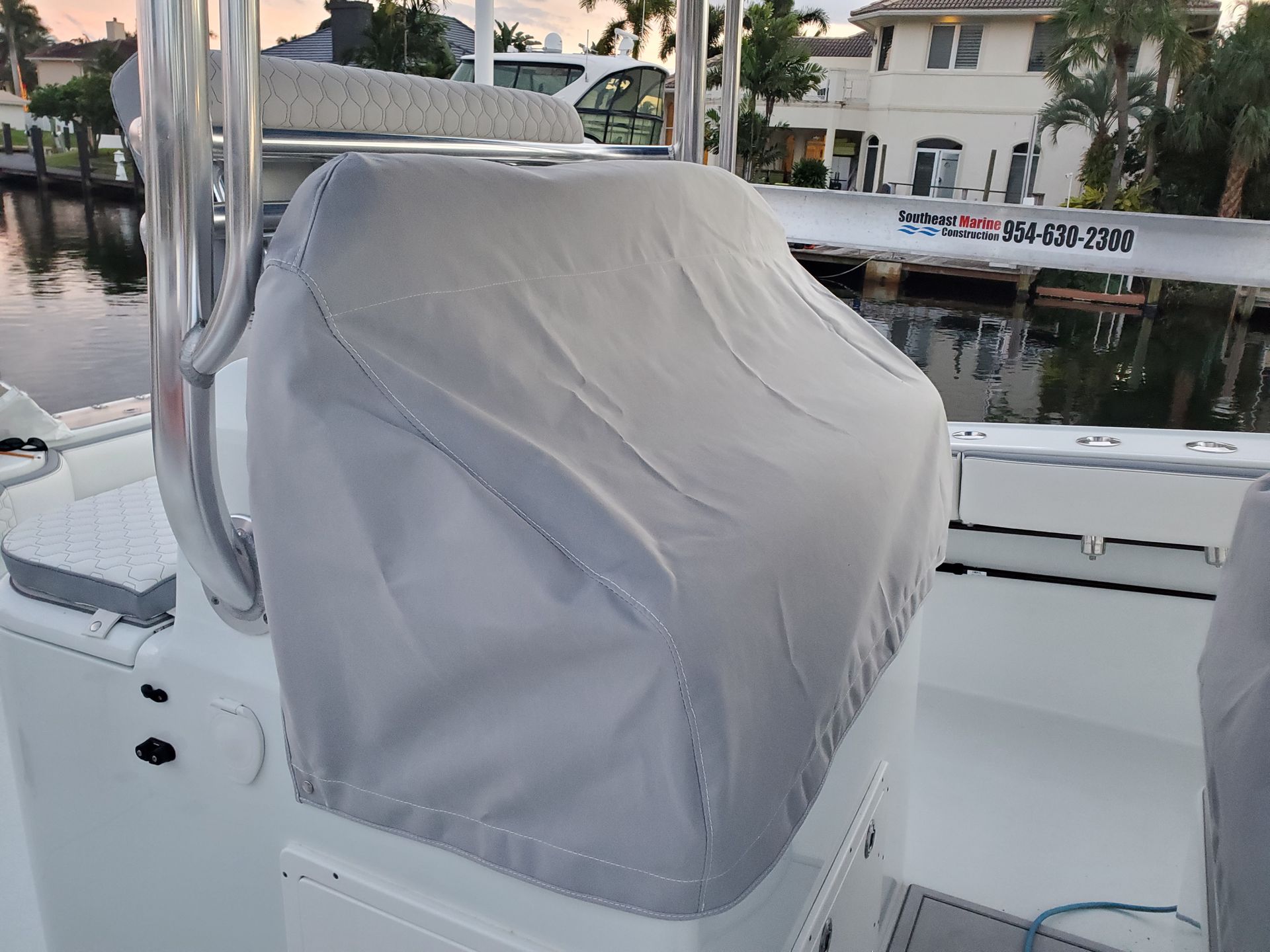 A boat with a seat cover on it is sitting in the water.