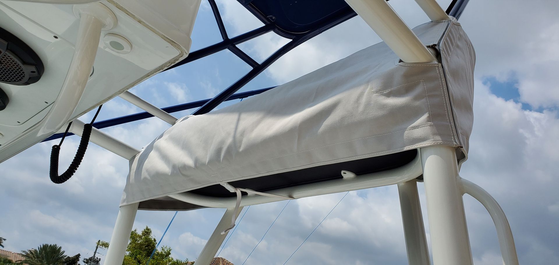 A white boat with a blue canopy on top of it.