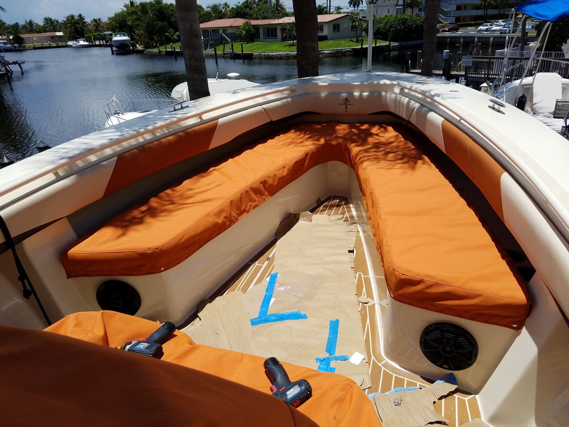 A boat with orange seats and a blue t on the floor