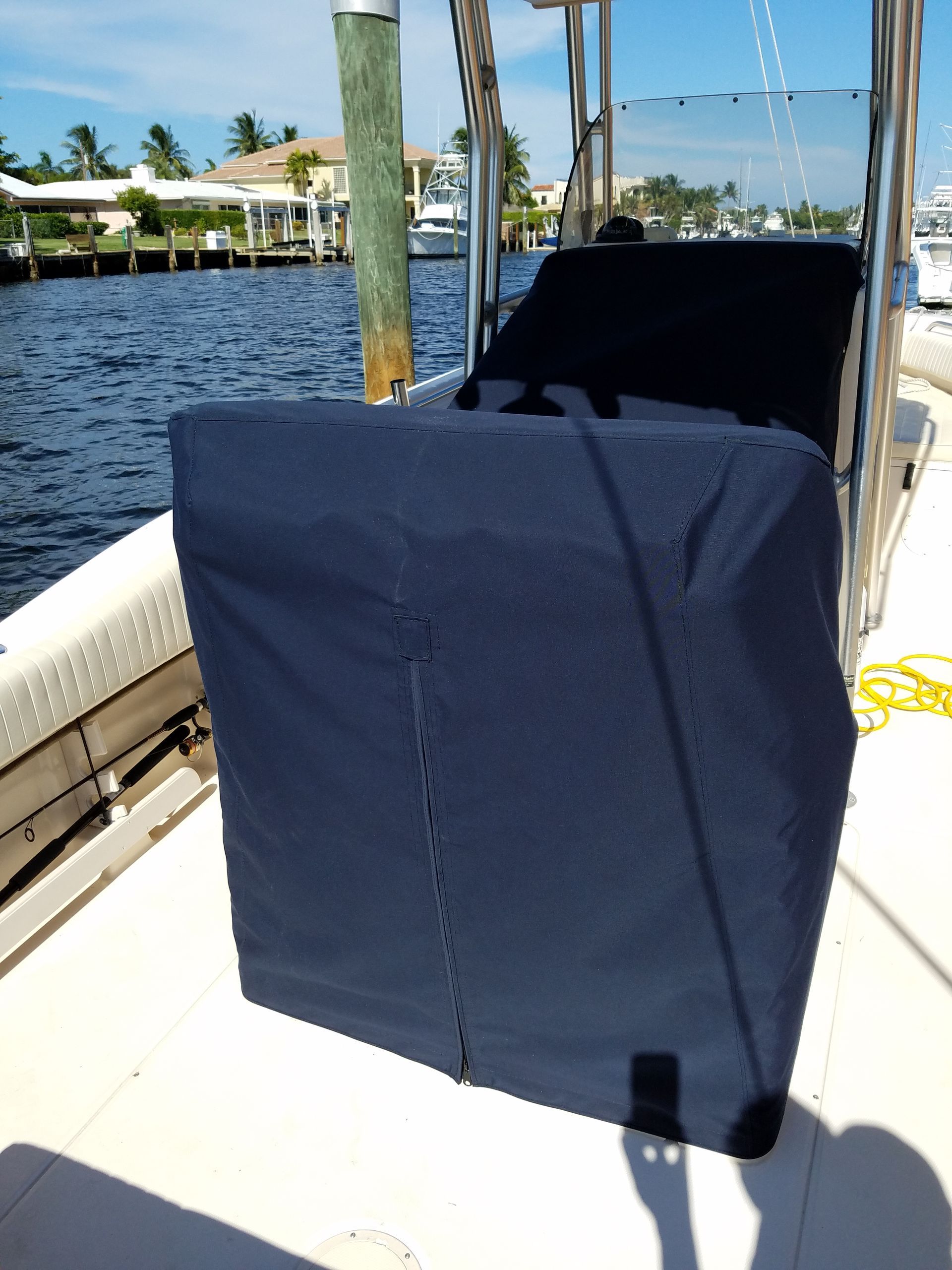 A boat with a blue cover on it is docked at a dock