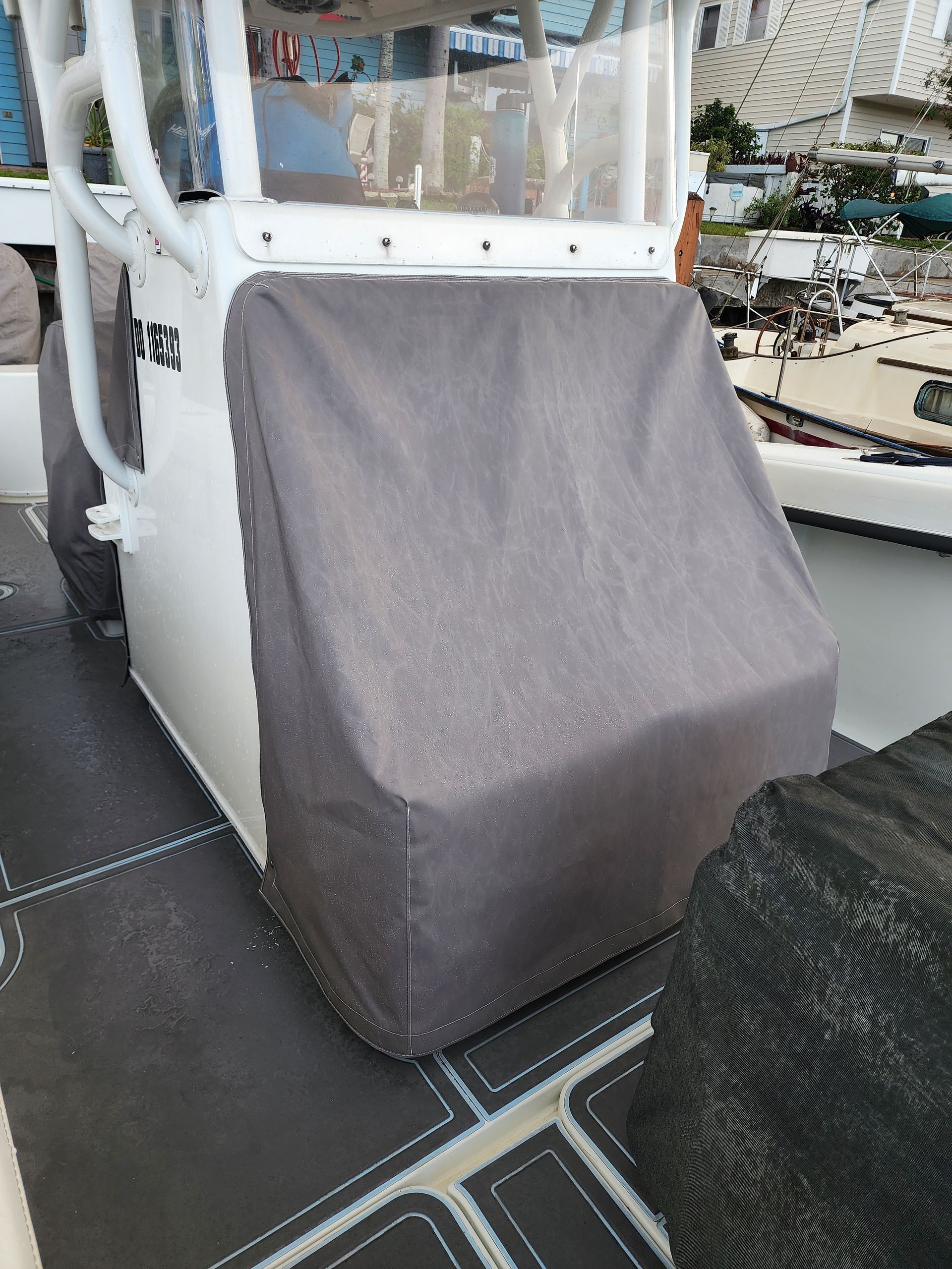 A boat with a cover on it is sitting on a dock.