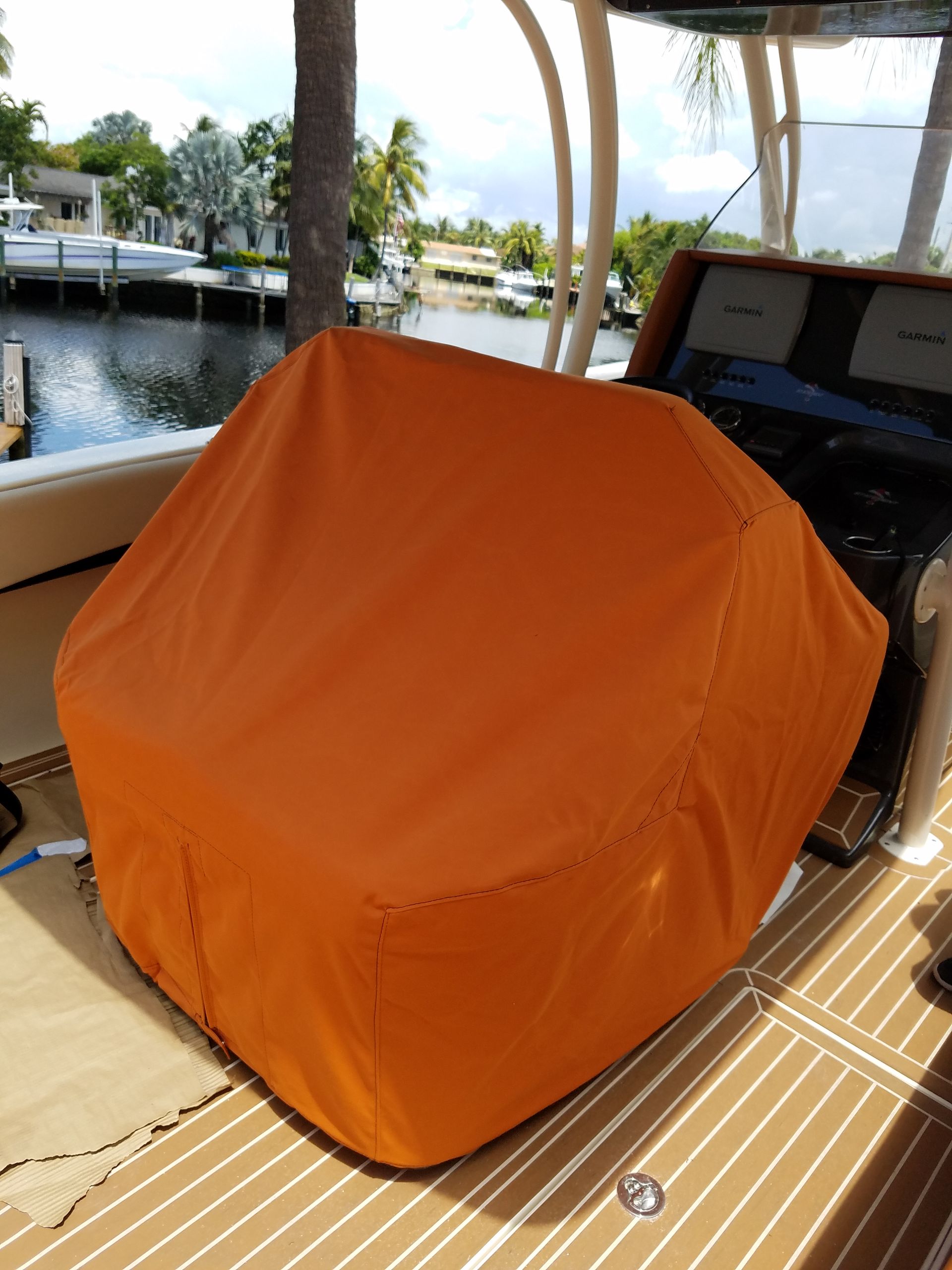 An orange cover sits on the steering wheel of a boat