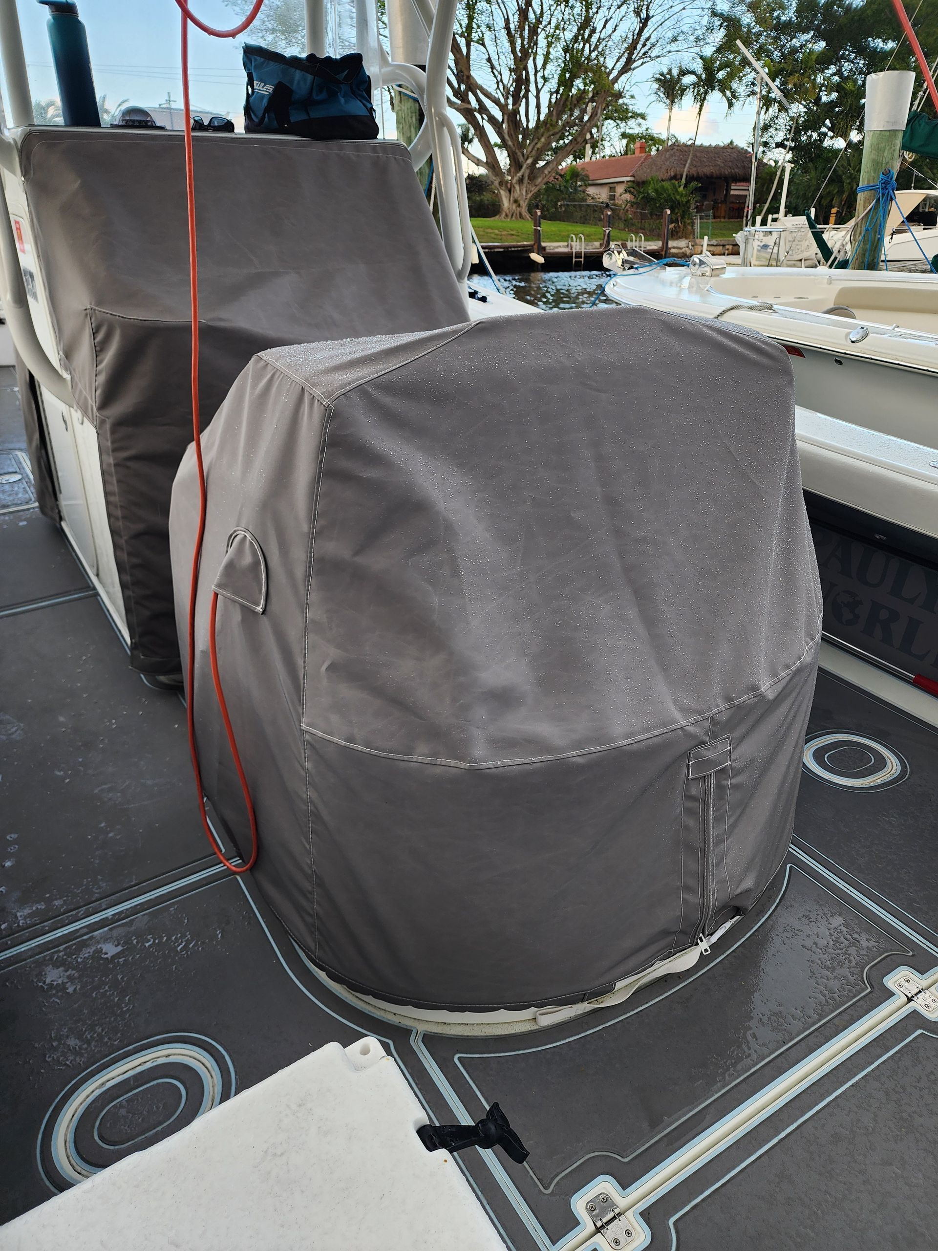A chair with a cover on it is sitting on the deck of a boat.