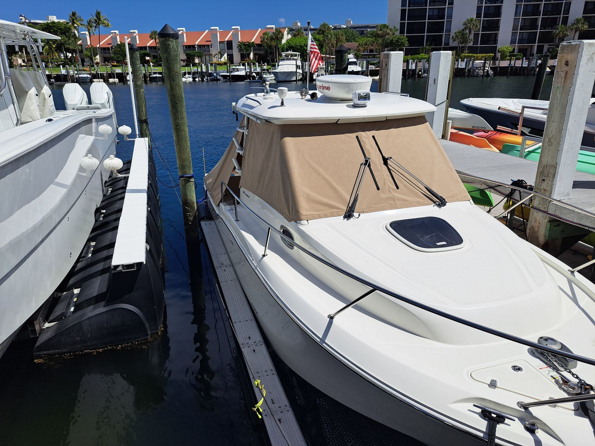 A white boat is docked at a dock in a marina
