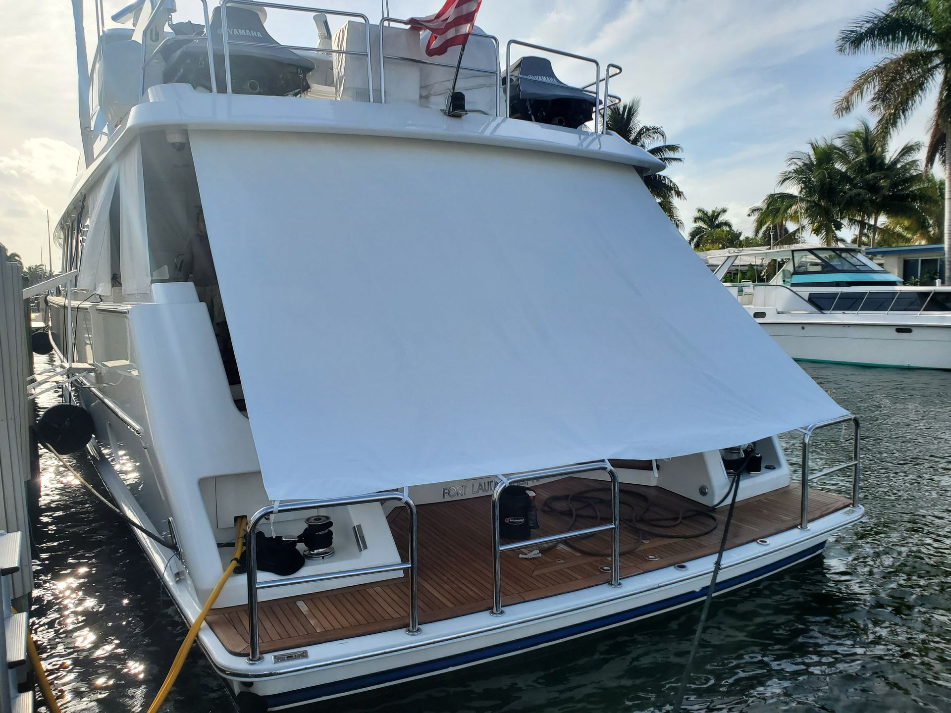 A boat with a white awning is docked in the water.