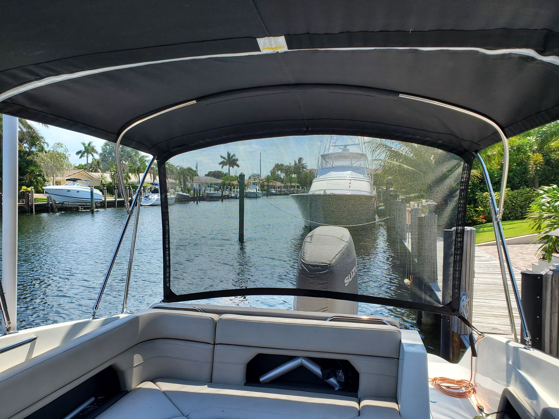 The inside of a boat with a canopy and a view of the water.