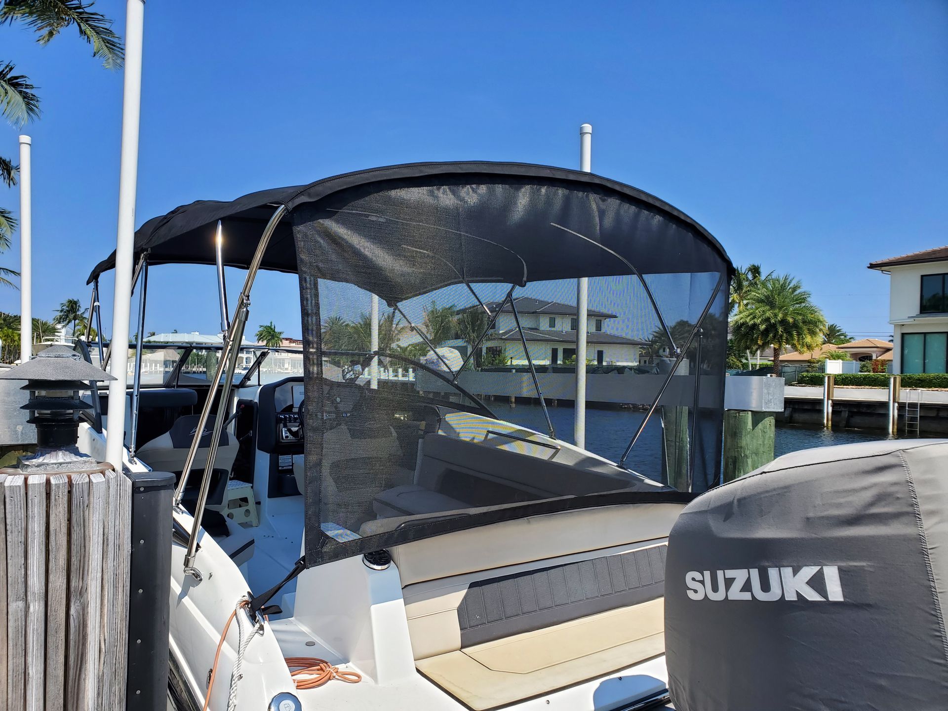 A boat with a suzuki engine is docked at a dock.