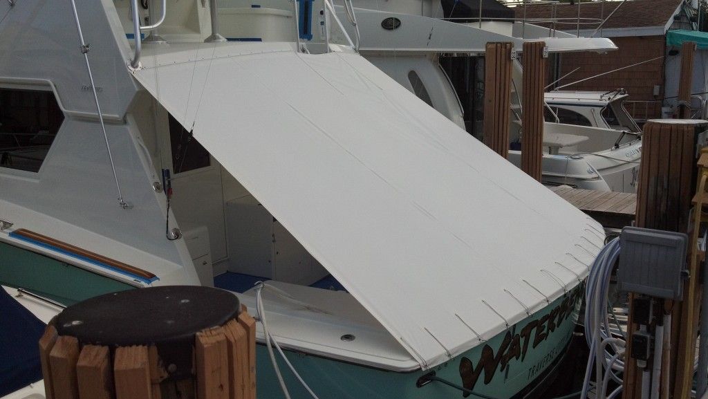 A boat with a white roof is docked at a dock