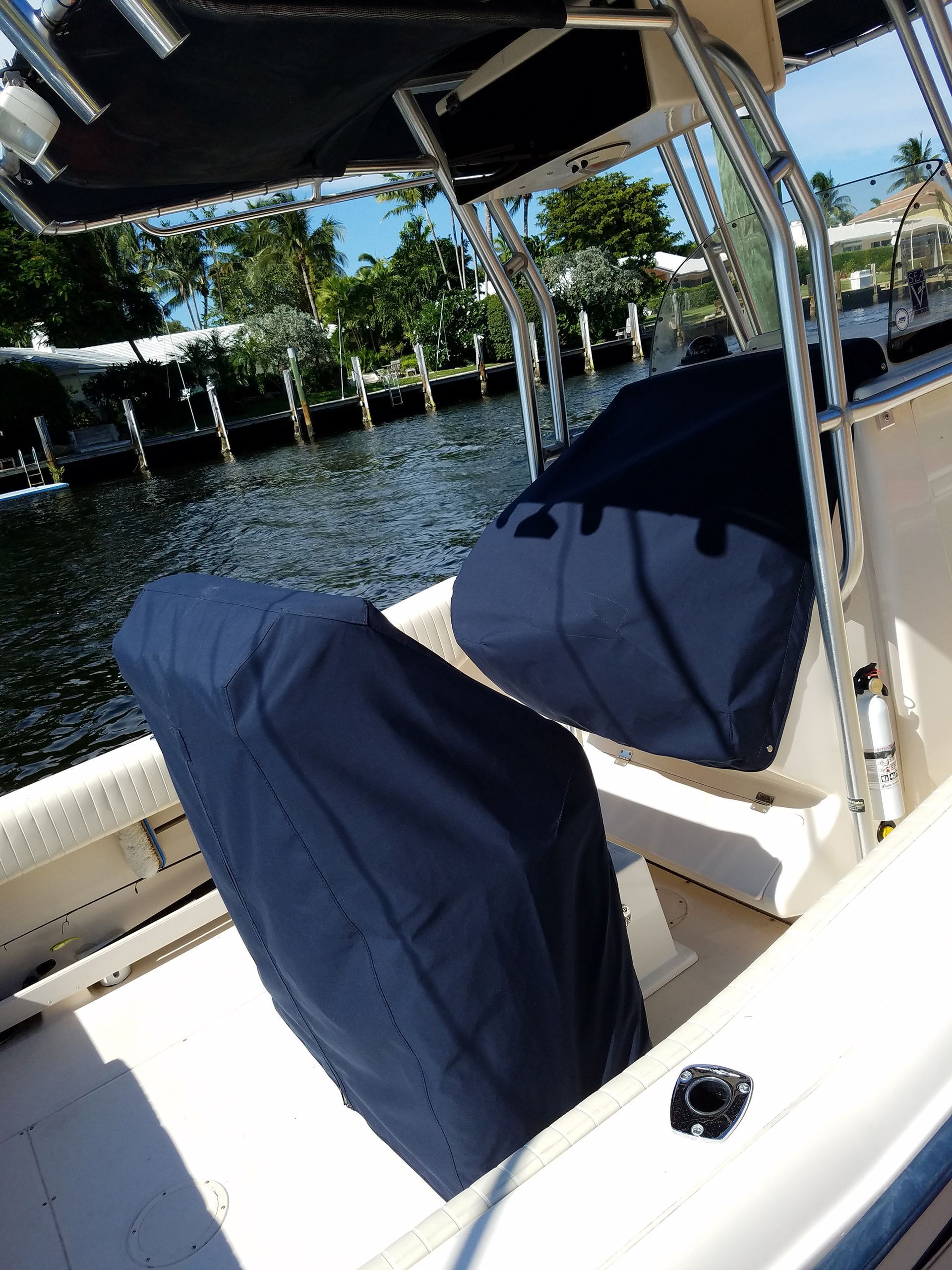A boat with a blue cover on the seats is in the water