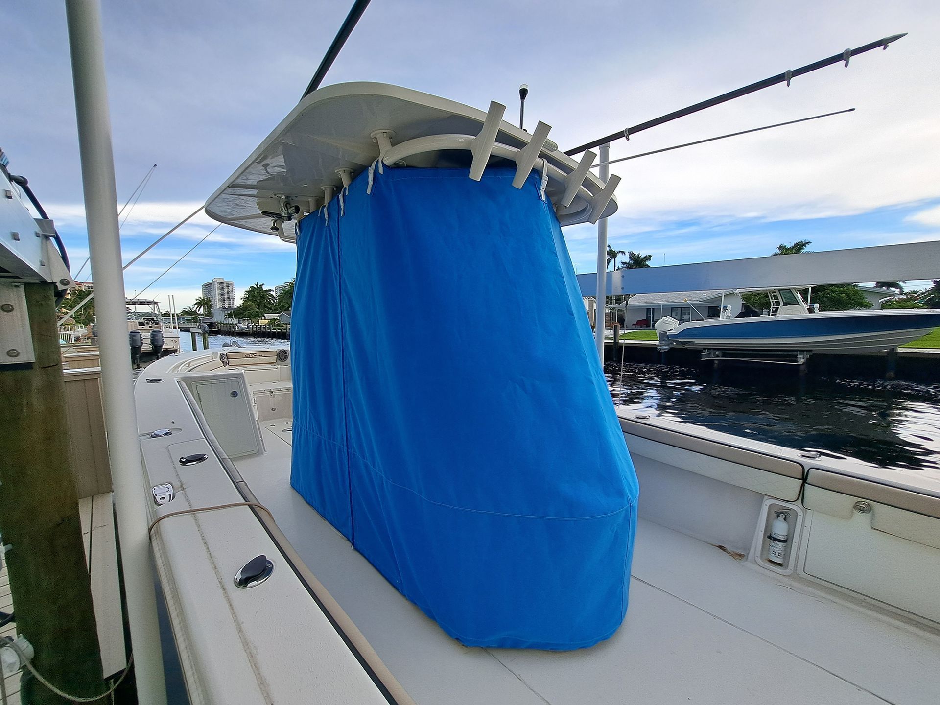 A boat with a blue cover on it is docked at a dock.