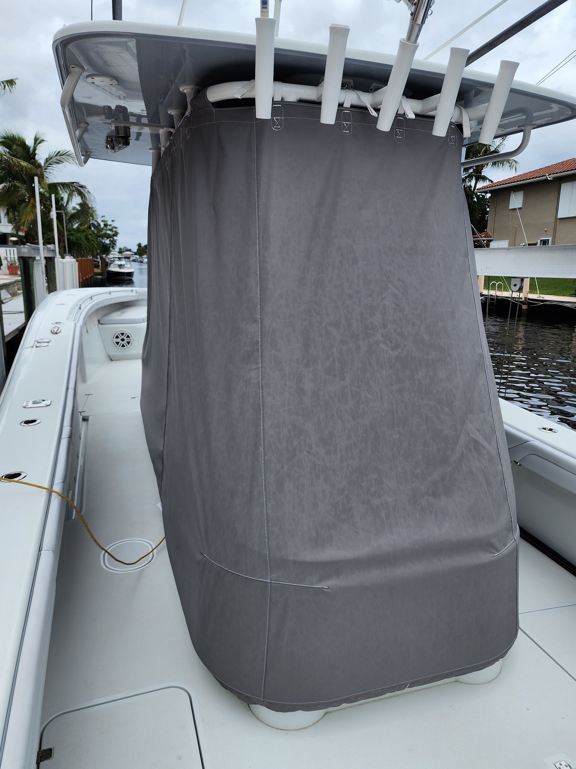 A white boat with a gray cover on the top of it.