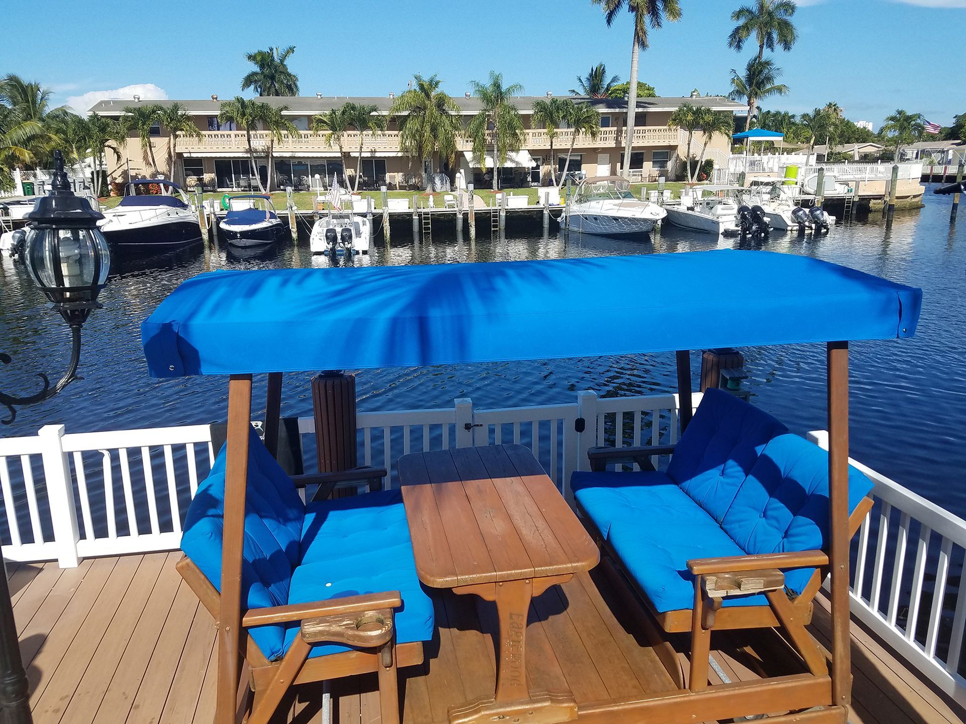 A dock with a blue canopy over a table and chairs