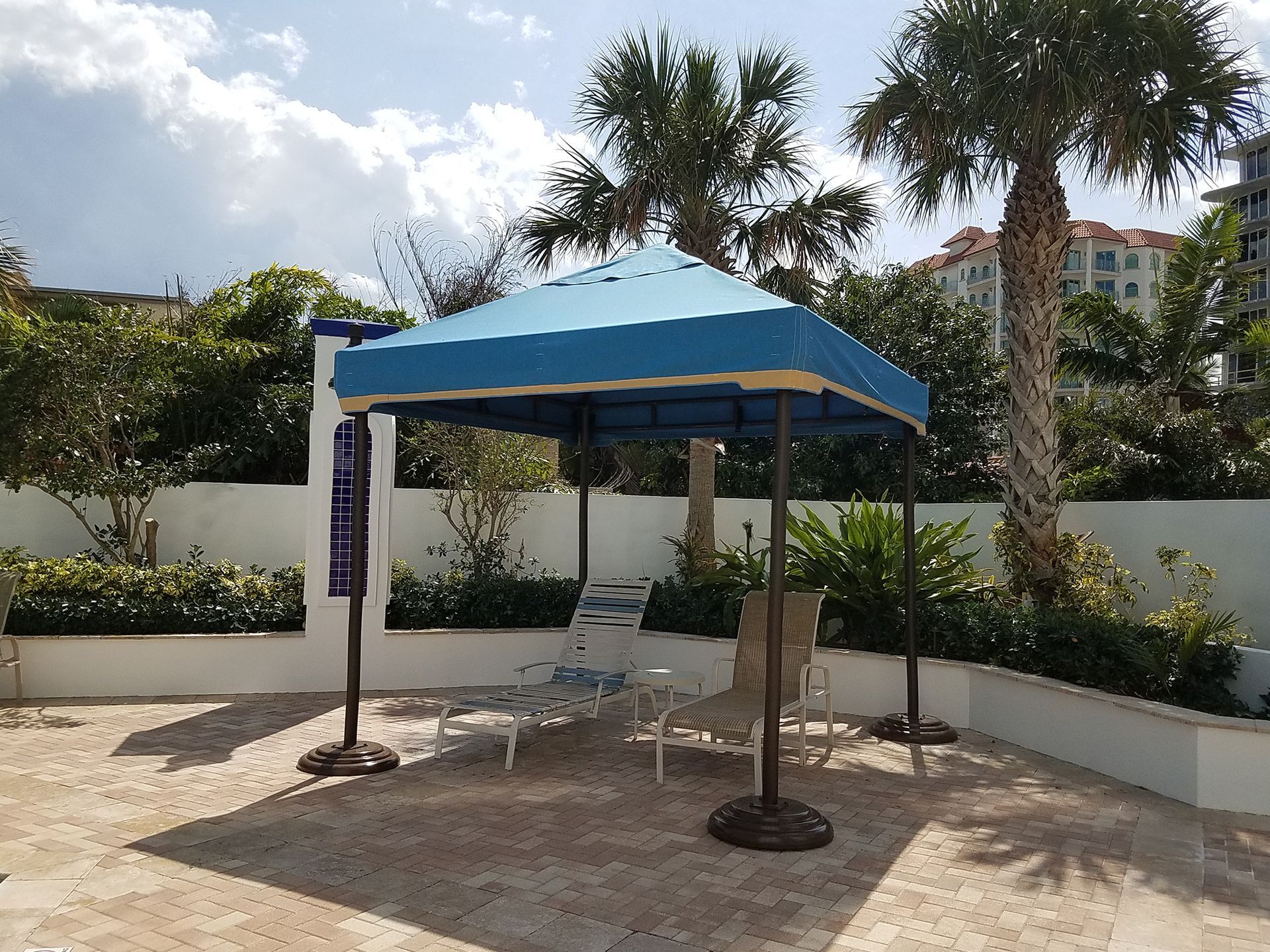 A gazebo with a blue umbrella and chairs