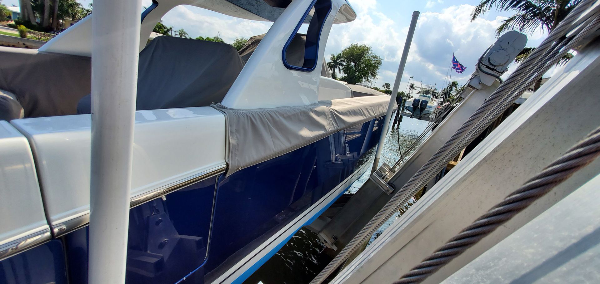 A blue and white boat is sitting on top of a dock.