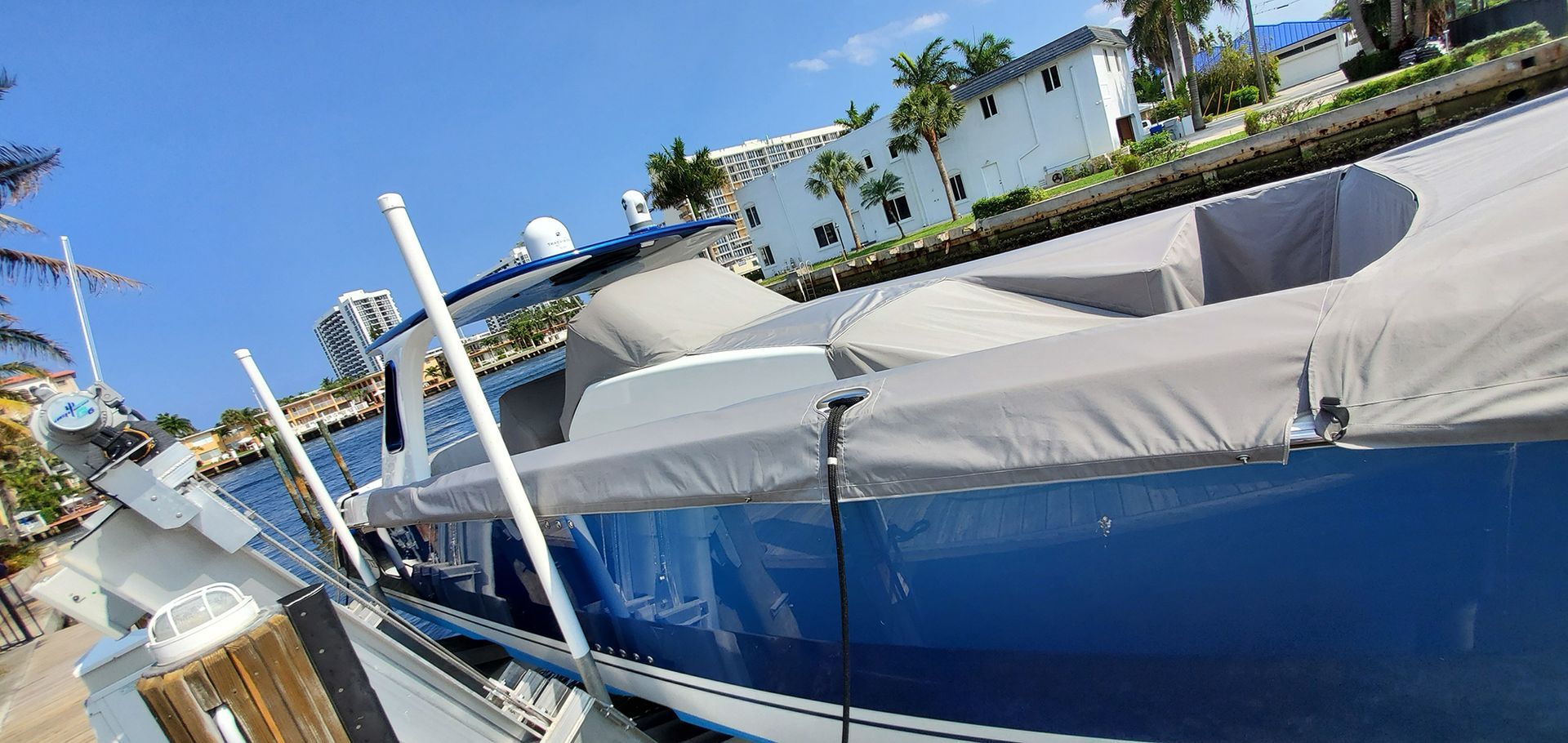 A boat is docked at a dock with a tarp on it.
