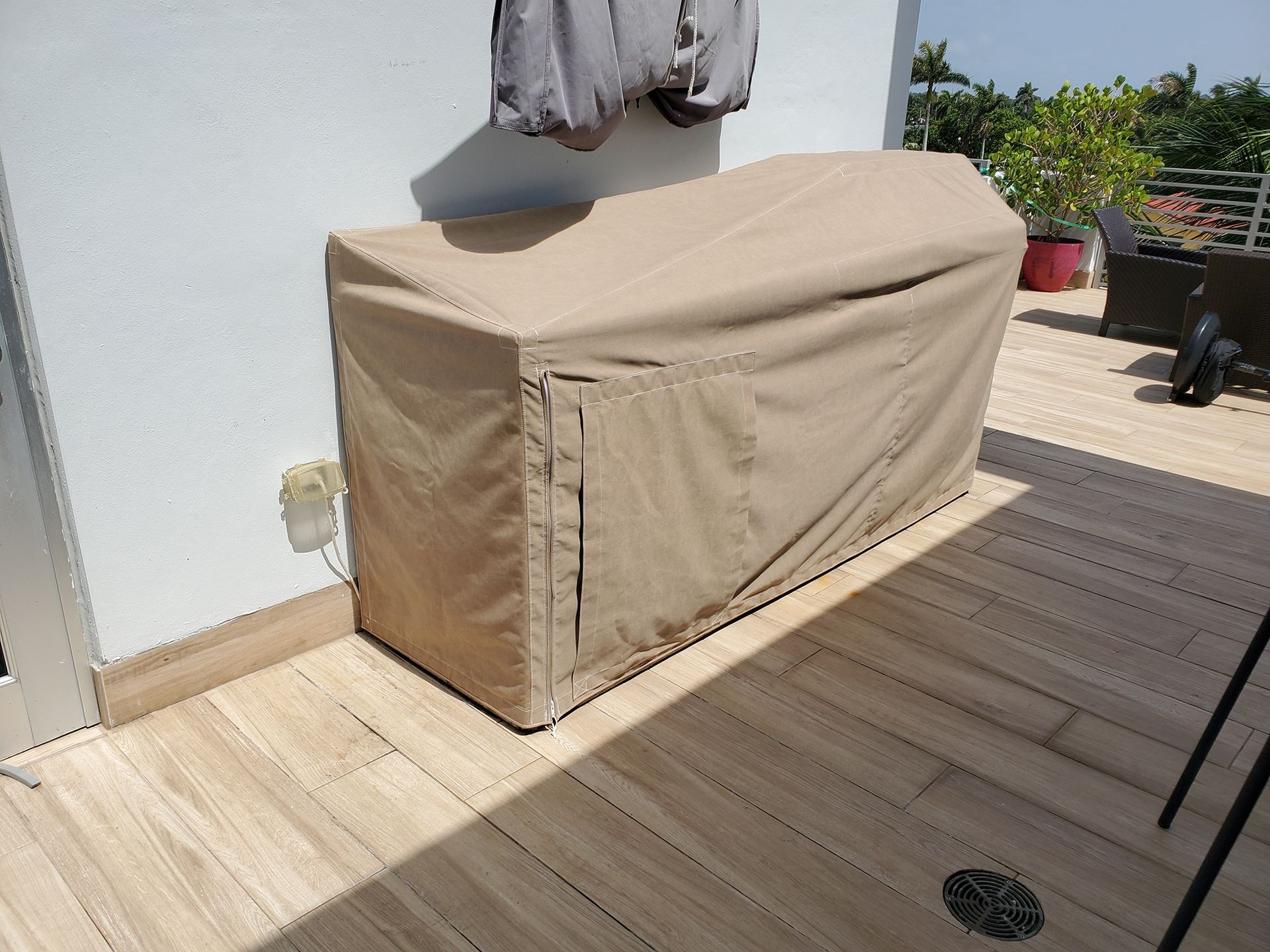 A tan cover is sitting on a wooden deck