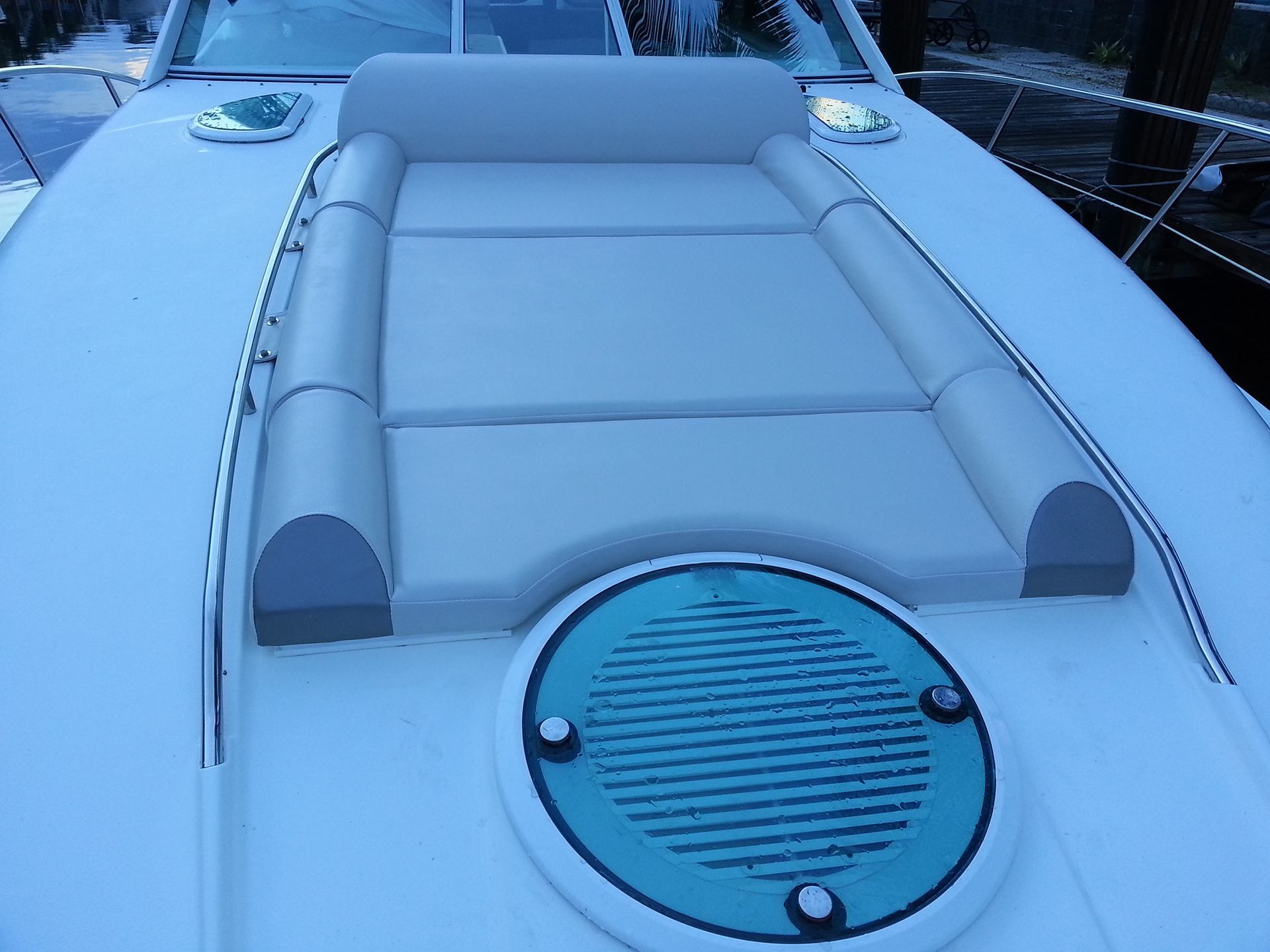 The front of a boat with a mattress and a speaker