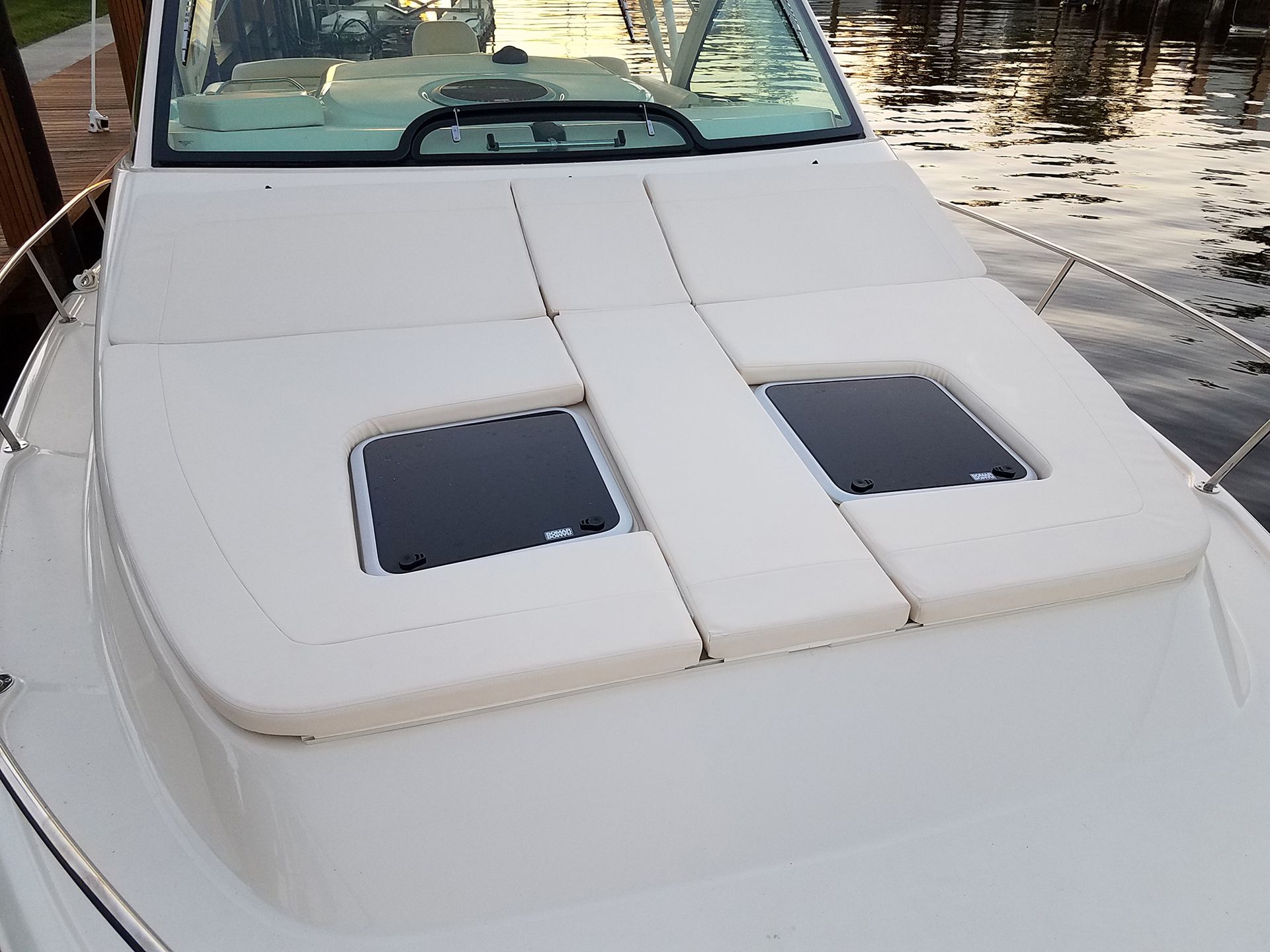 The front of a white boat with two seats and a steering wheel.