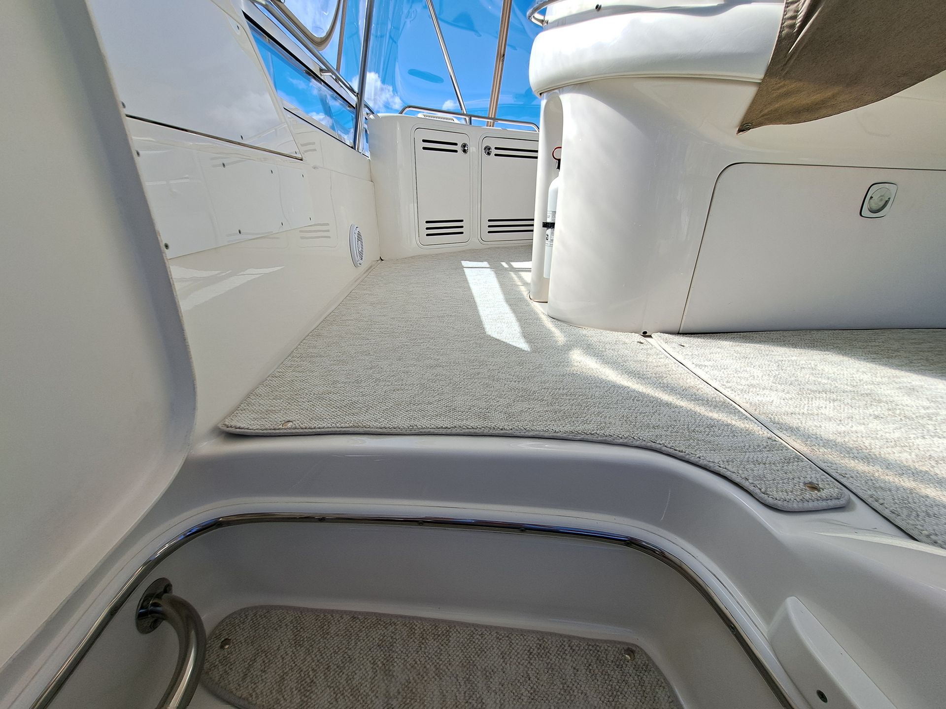 A boat with a carpeted floor and a staircase leading to it.