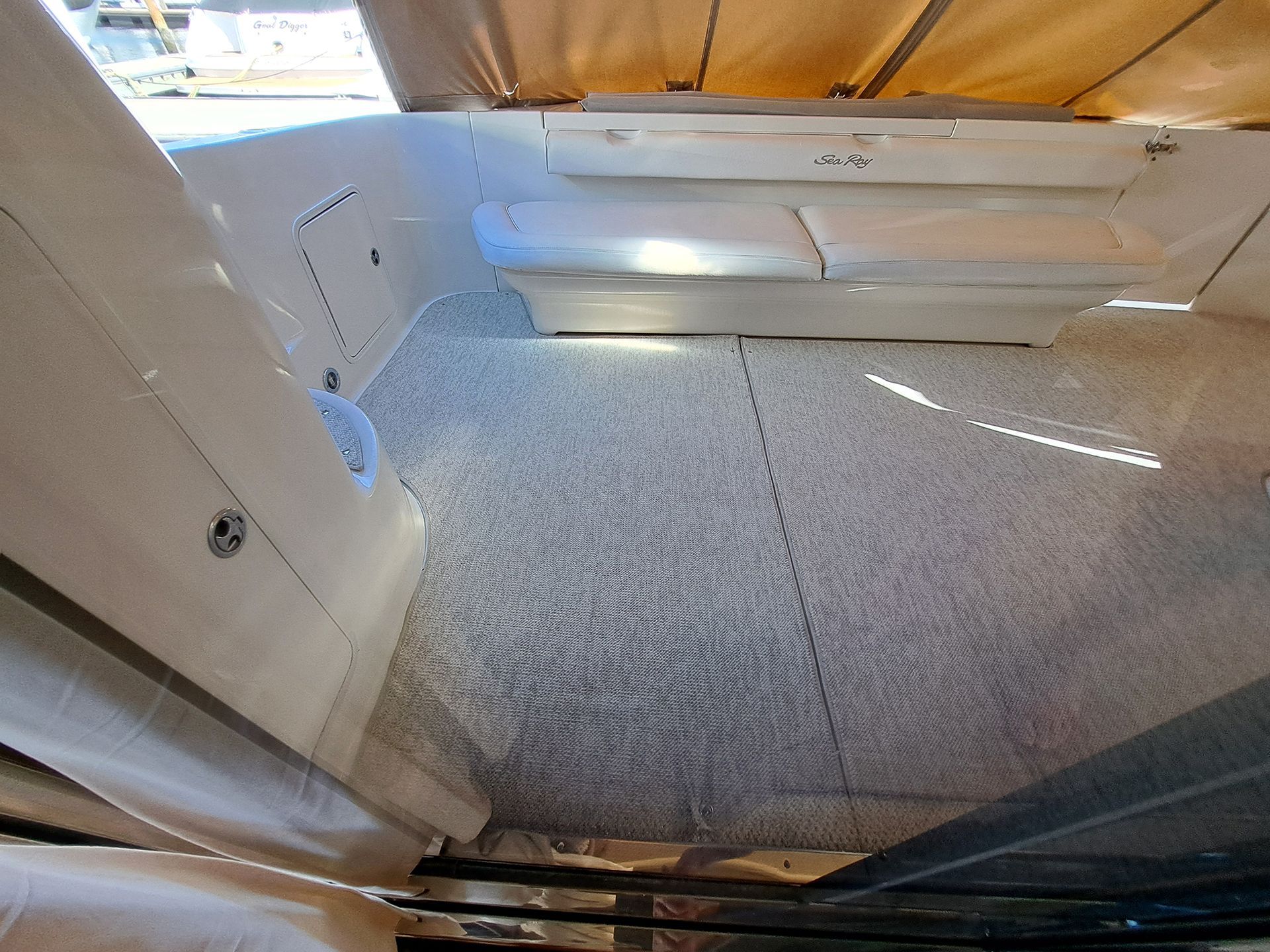 The inside of a boat with a carpeted floor.