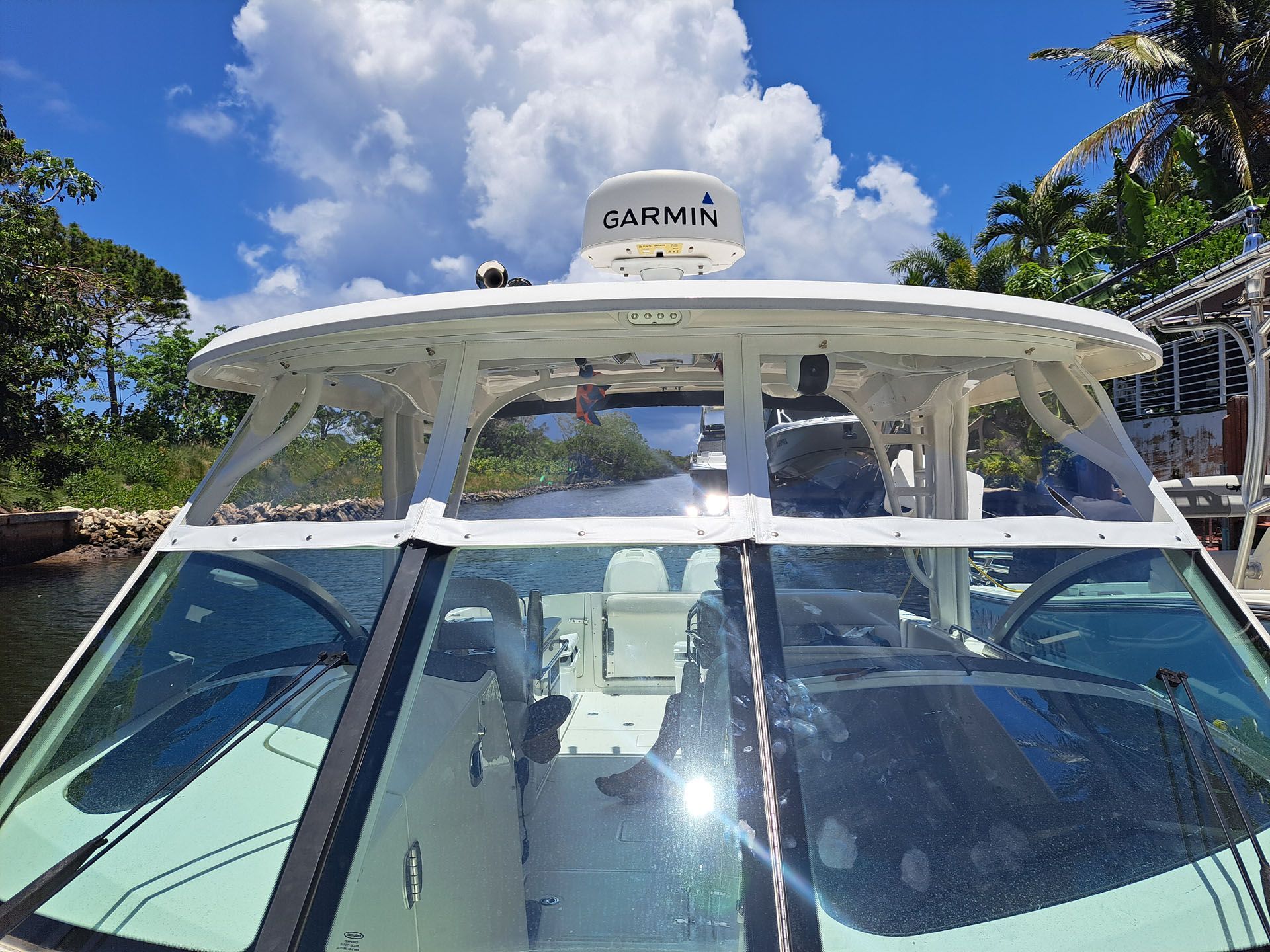White boat cabin with clear windshield, Garmin radar, blue sky.