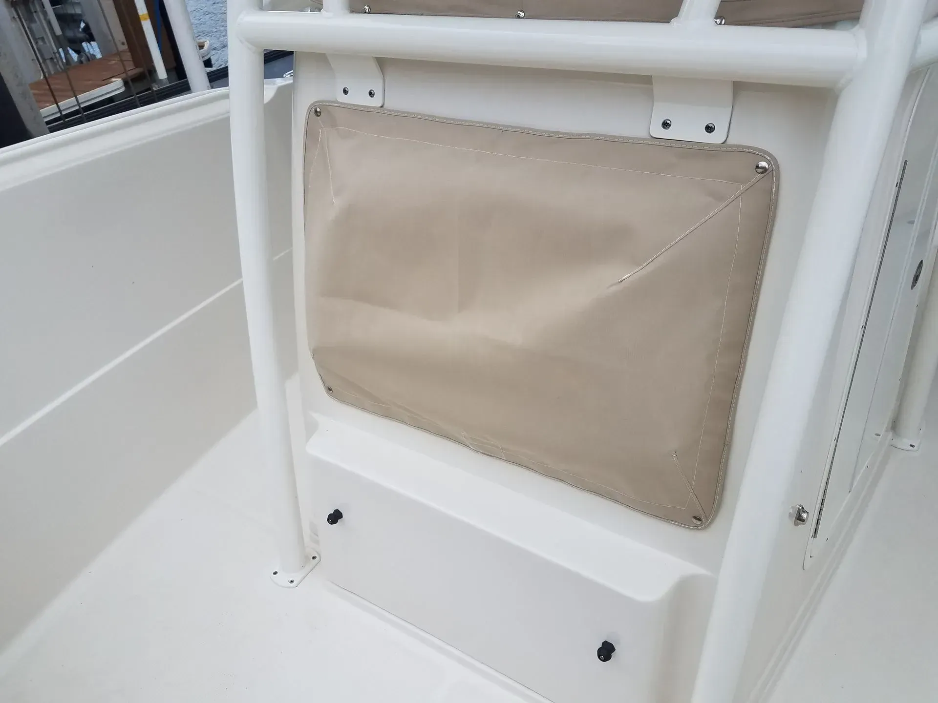 Beige storage pocket on a boat with white framework.