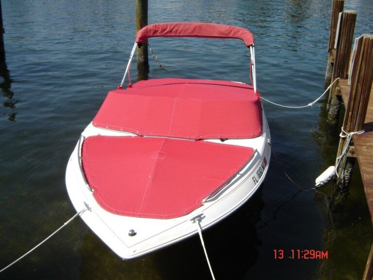 A red and white boat is tied to a dock at 11:29 am