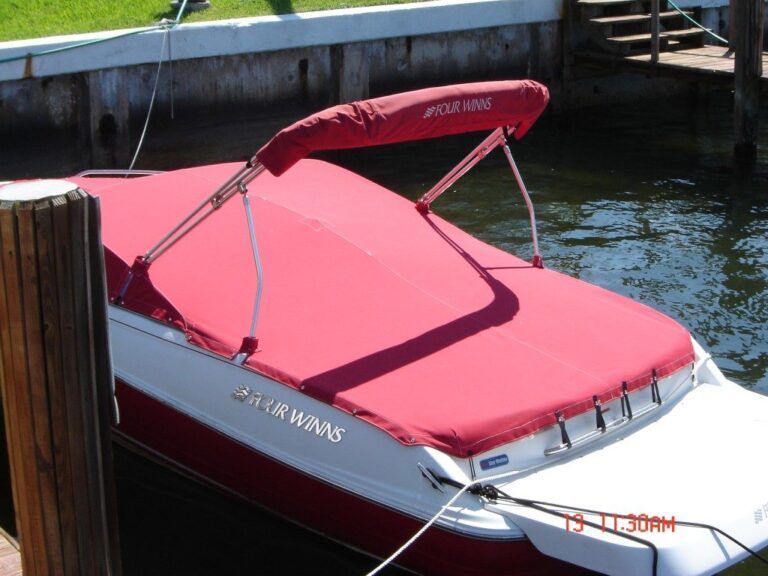 A red and white boat is docked at a dock