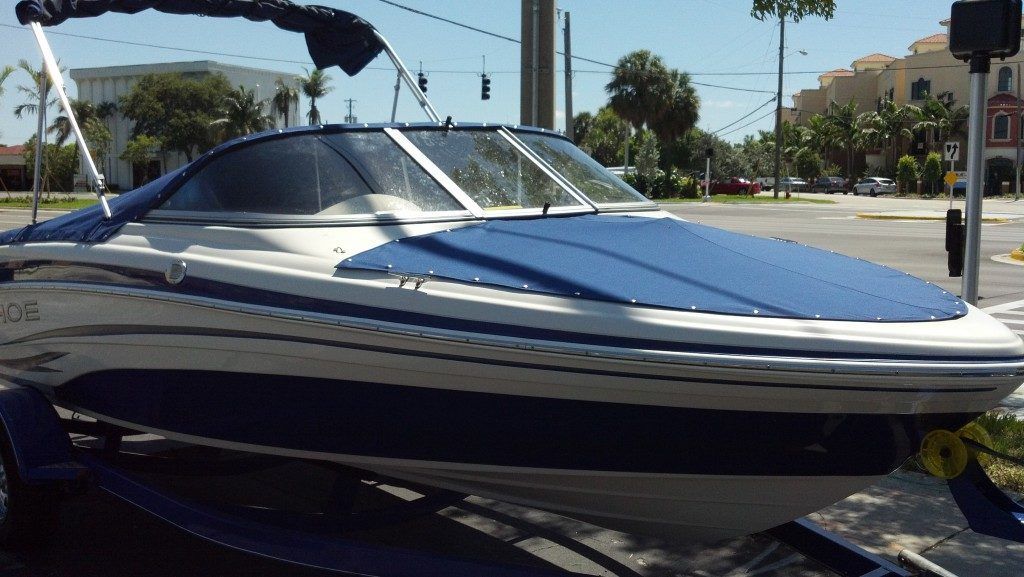 A blue and white boat is parked on the side of the road