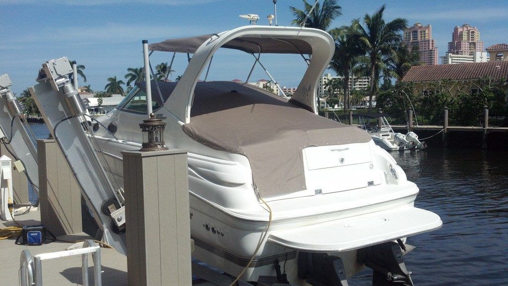 A white boat is docked at a dock in the water