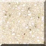 Close-up of a beige, speckled stone or tile surface with a square edge visible at the bottom right.