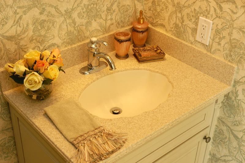 Bathroom vanity with cream sink, chrome faucet, yellow flowers, and countertop decor on a beige background