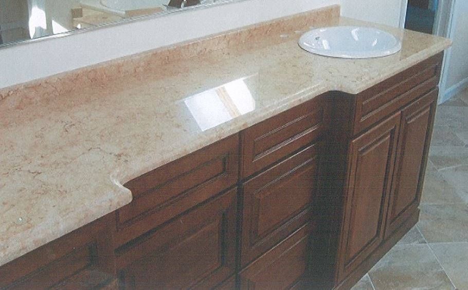 Brown bathroom vanity with granite countertop, built-in sink, and white backsplash wall backing