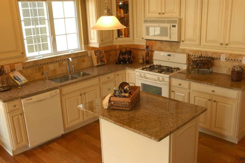Spacious kitchen with wooden cabinets, granite island, white appliances, and a window over the sink.