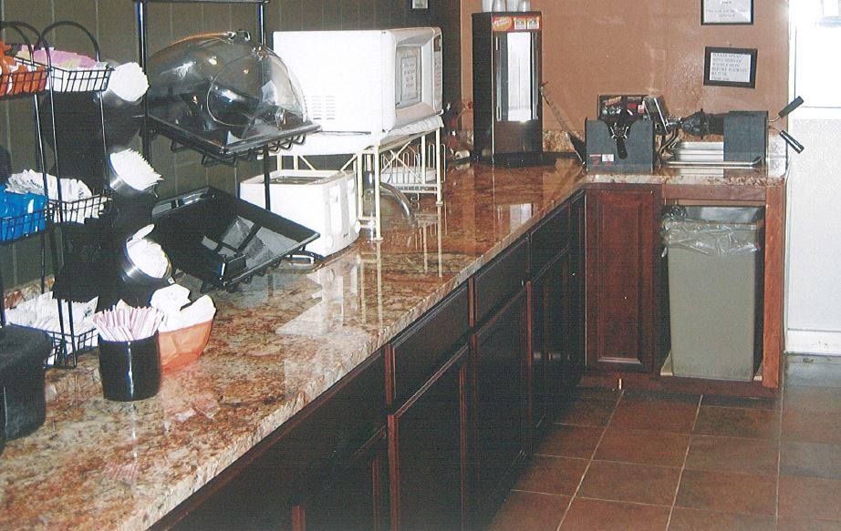 Coffee shop counter with pastry rack, shiny granite top, and tiled floor