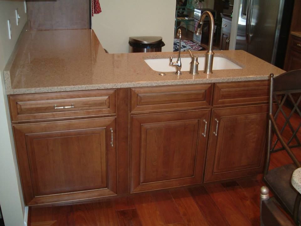 Wooden kitchen island with sink and light countertop in a home interior
