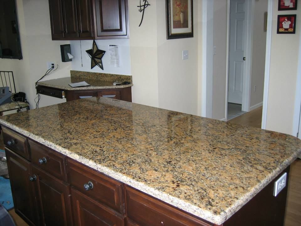 Granite kitchen island countertop with dark wood cabinets in a home kitchen