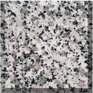 Speckled gray and white granite surface with black flecks