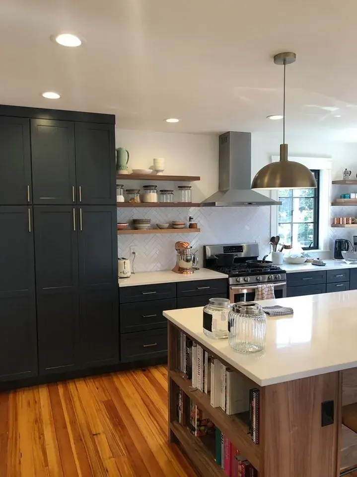 Modern kitchen with dark blue cabinets, wooden shelves, white countertops, and wood floor.