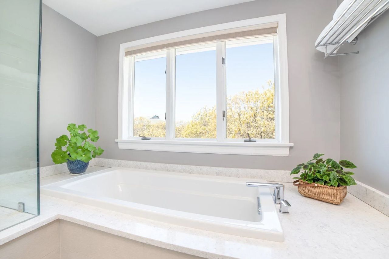 A bathroom with a bathtub and a window.