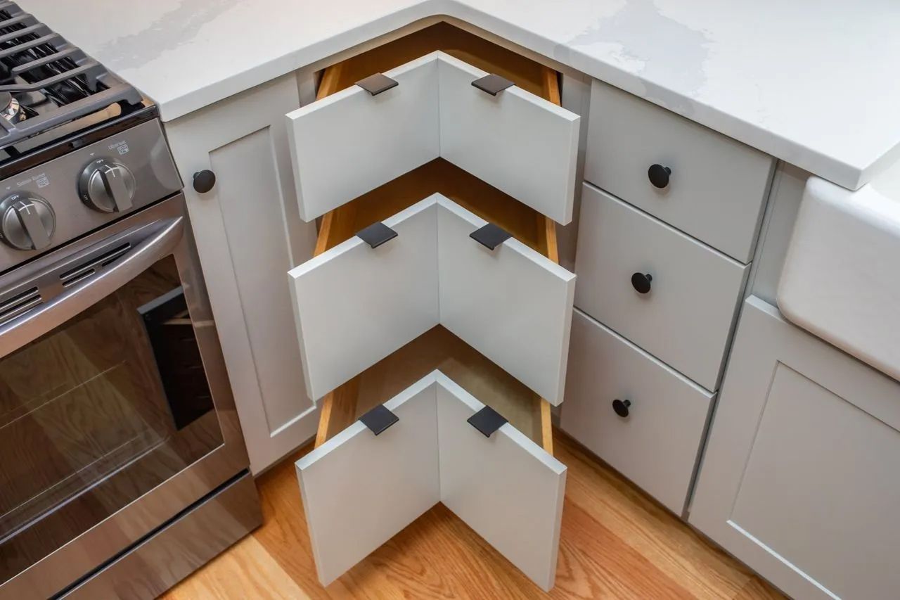 A kitchen with stainless steel appliances, white cabinets, and wooden floors.
