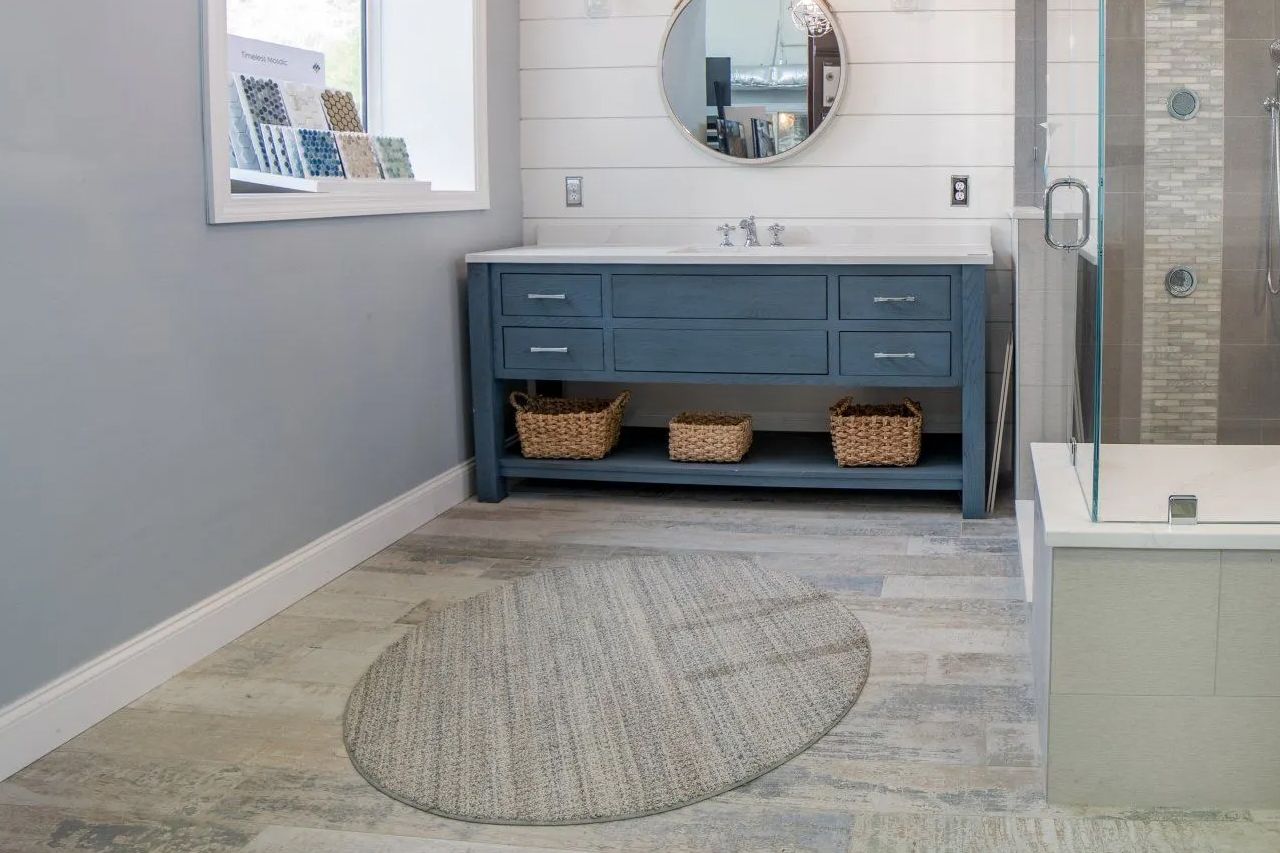 A bathroom with a sink, mirror, and rug.