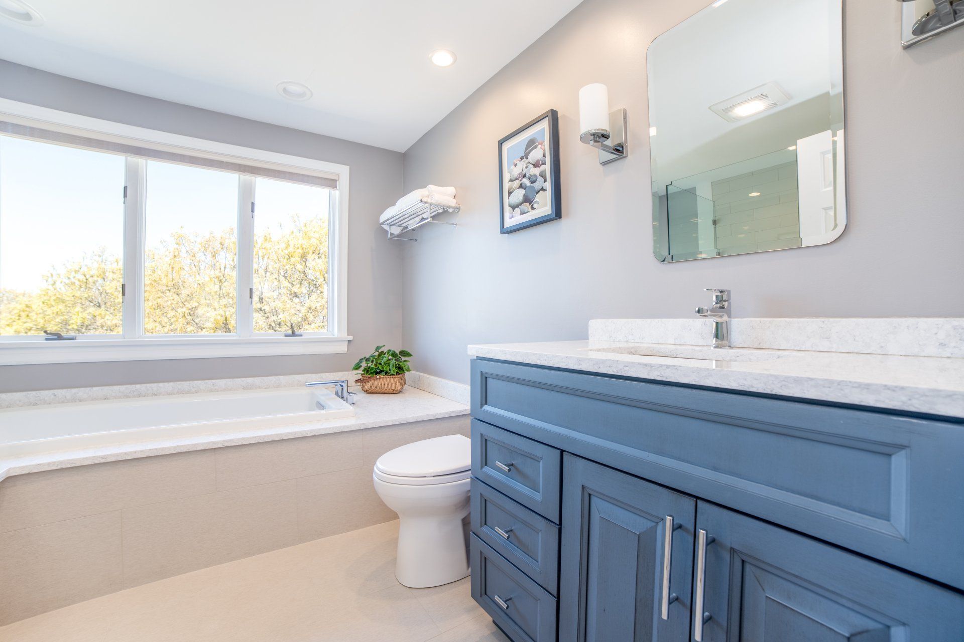 A bathroom with a toilet , sink , tub and mirror.
