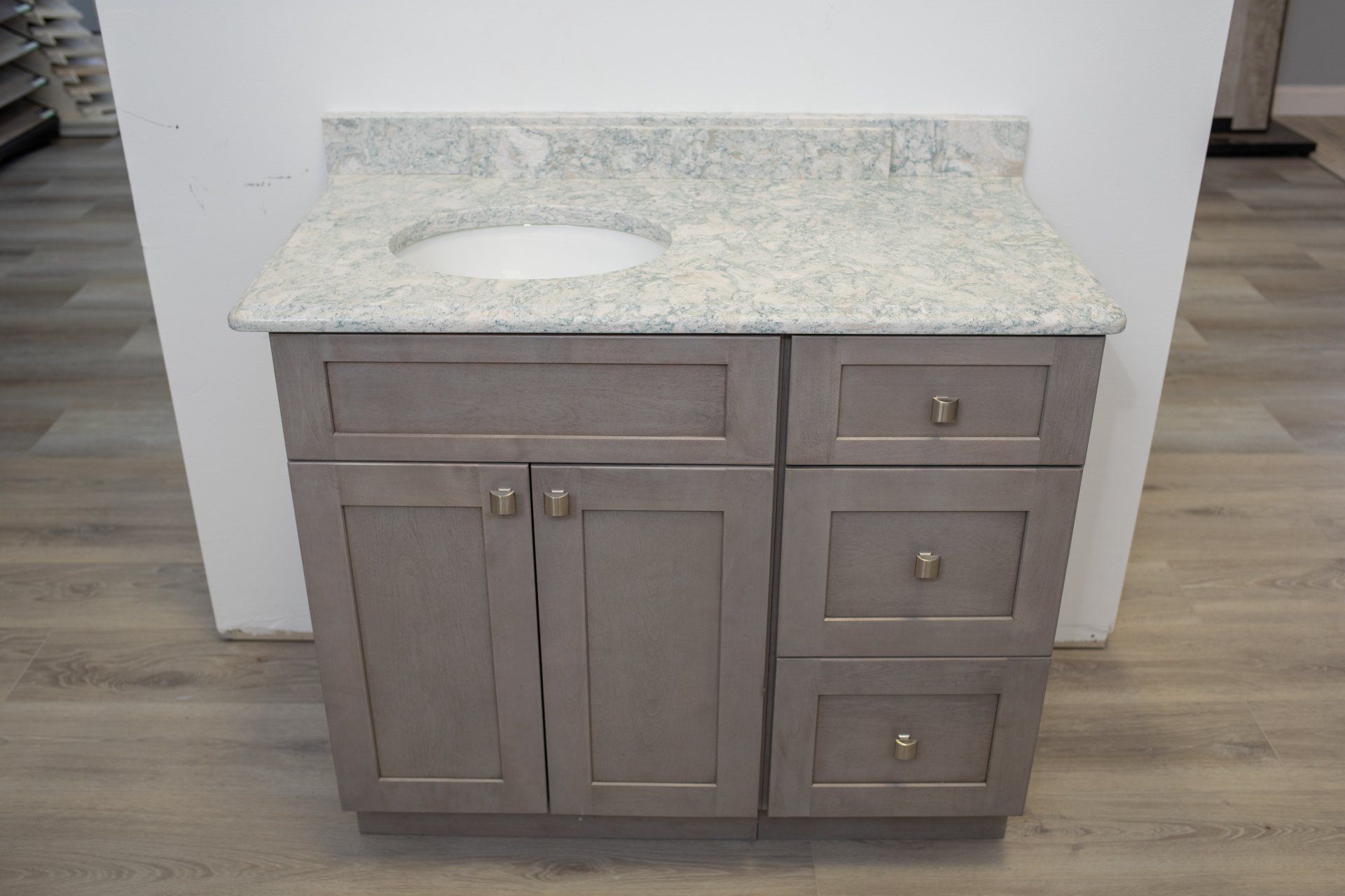 A bathroom vanity with a sink and granite counter top