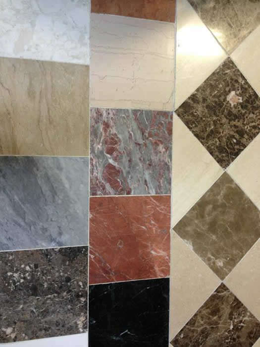 A display of different colored marble tiles with a checkered floor in the background