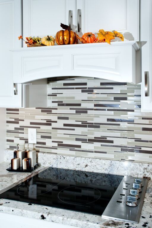 A kitchen with a stove top oven and a hood.