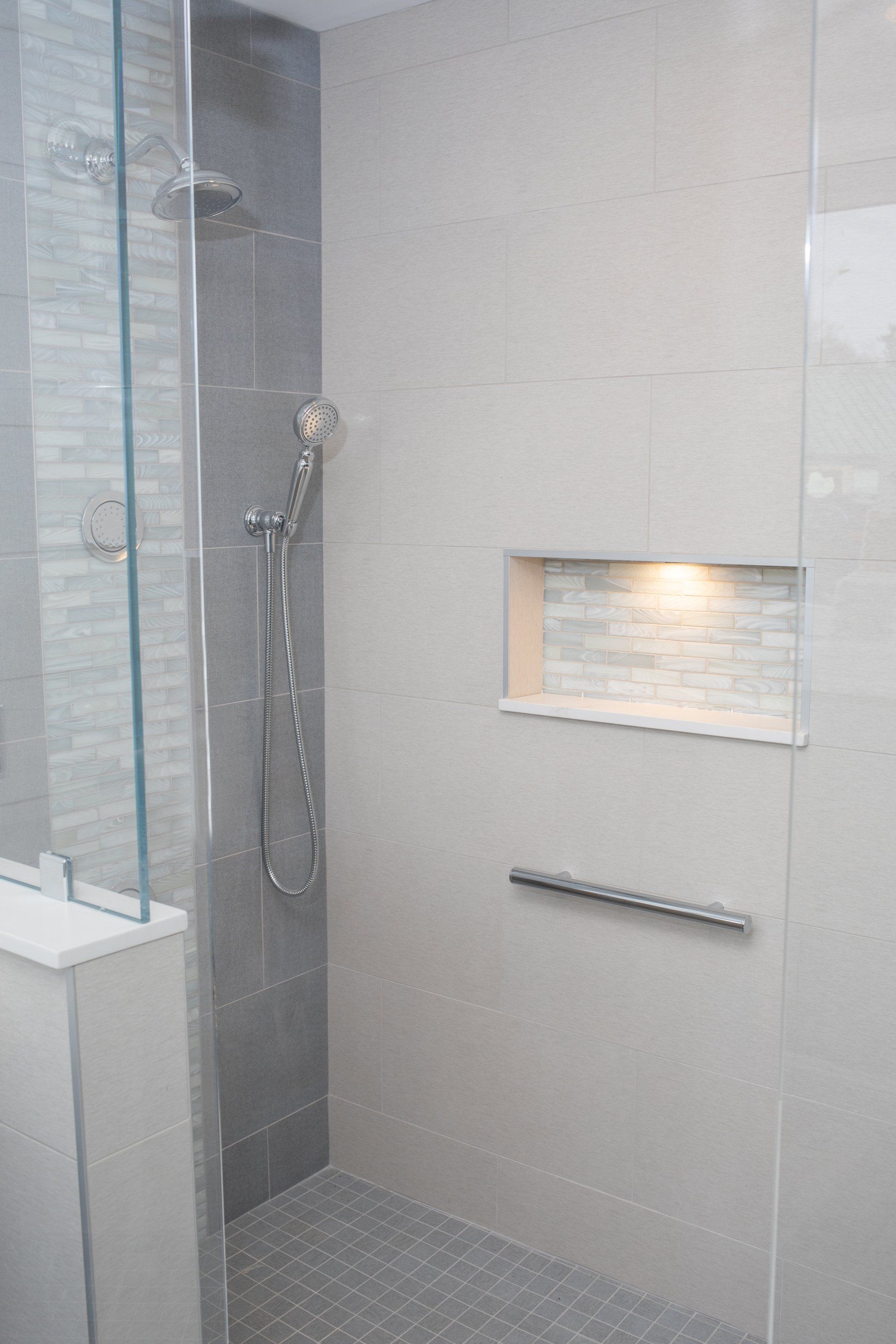 A bathroom with a walk in shower with a glass door