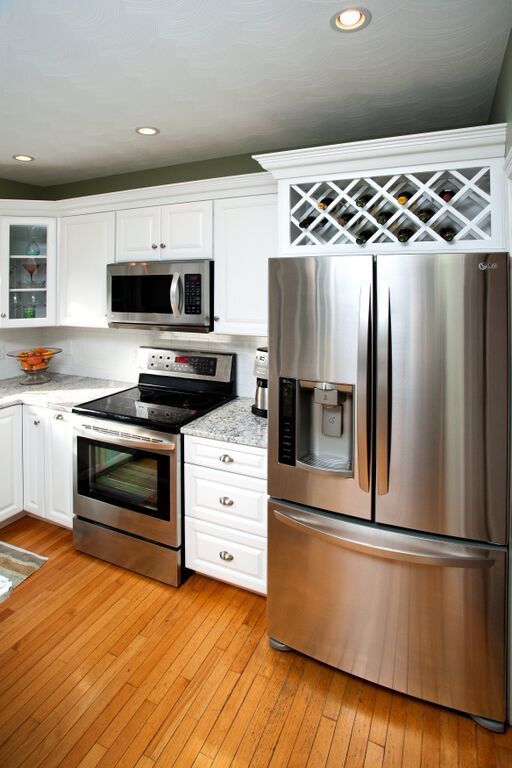 A kitchen with a stainless steel refrigerator , stove , and microwave.